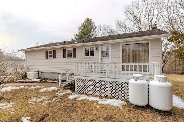 rear view of property with a chimney and a wooden deck