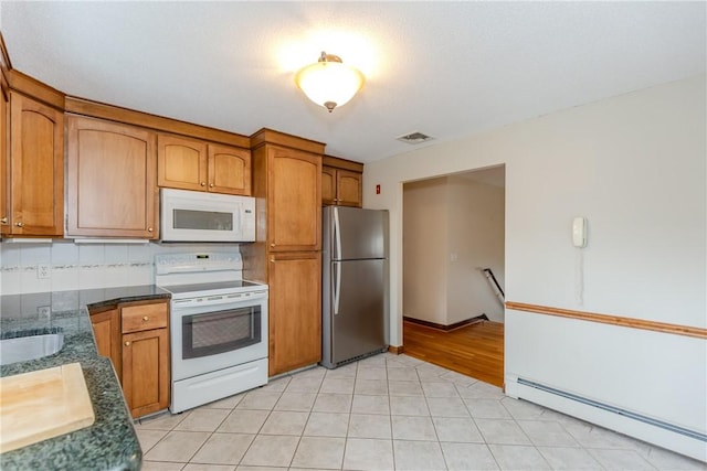 kitchen featuring white appliances, visible vents, decorative backsplash, brown cabinets, and a baseboard heating unit