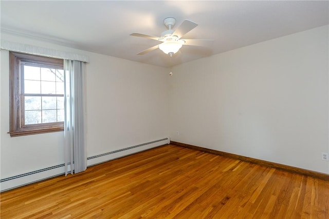 spare room featuring baseboards, baseboard heating, a ceiling fan, and light wood-style floors