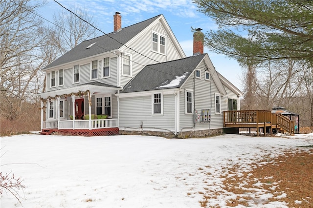 exterior space featuring a porch, roof with shingles, and a chimney