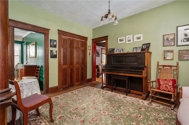 living area featuring an inviting chandelier, baseboards, and wood finished floors