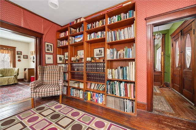 sitting room featuring wood-type flooring, baseboards, and wallpapered walls