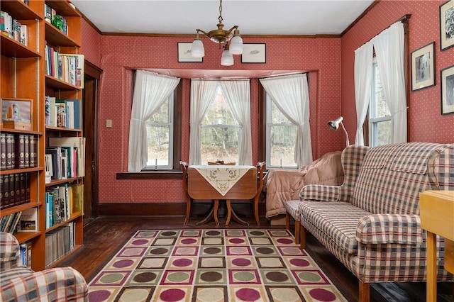 sitting room with wallpapered walls, baseboards, ornamental molding, wood finished floors, and a notable chandelier