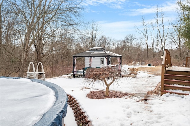 yard layered in snow with a gazebo