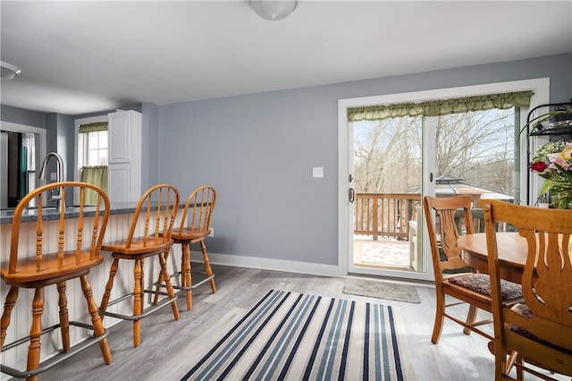 dining area with light wood-type flooring and baseboards