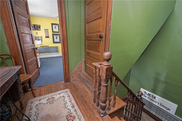 hall featuring wood finished floors and an upstairs landing