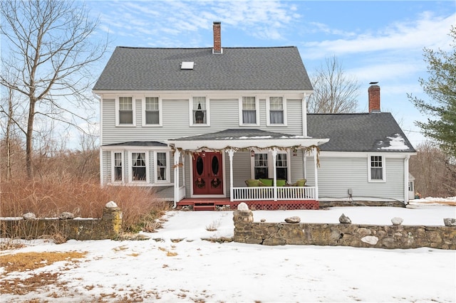 view of front of home featuring a porch, a shingled roof, and a chimney