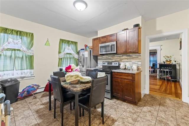 107 Lenox Ave, Providence, RI 02907 - kitchen with light tile patterned floors, stainless steel appliances, light countertops, and decorative backsplash
