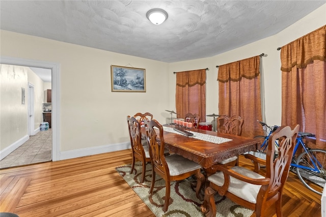 107 Lenox Ave, Providence, RI 02907 - dining room with light wood-type flooring, a textured ceiling, and baseboards