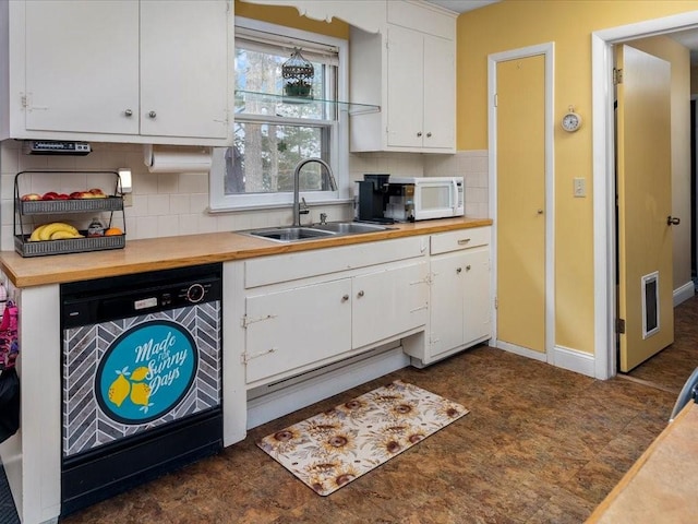 kitchen with butcher block counters, white microwave, white cabinetry, a sink, and dishwasher