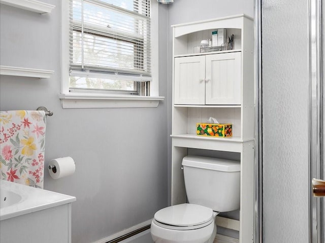 bathroom featuring vanity, toilet, and baseboards