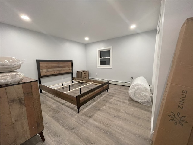 bedroom featuring baseboard heating, wood finished floors, and recessed lighting