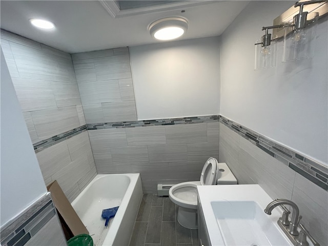 full bath with a tub to relax in, toilet, wood finish floors, a sink, and tile walls