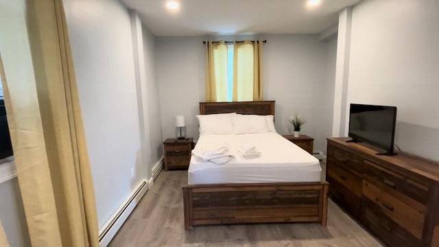 bedroom with recessed lighting, a baseboard radiator, and light wood-style floors