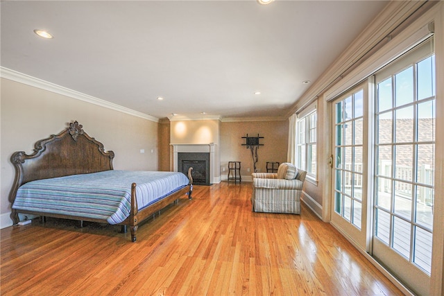 bedroom featuring recessed lighting, a fireplace with flush hearth, baseboards, light wood-style floors, and ornamental molding