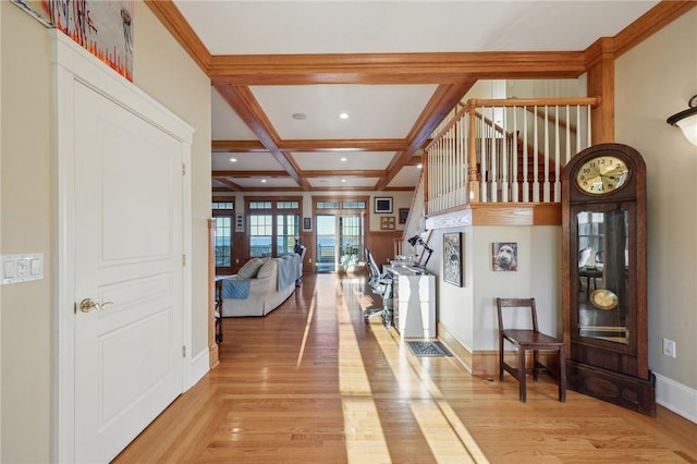 interior space with light wood-style floors, beam ceiling, coffered ceiling, and baseboards