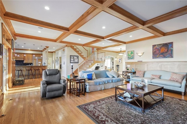 living area with light wood-type flooring, arched walkways, coffered ceiling, and stairway