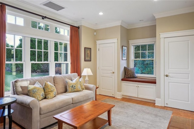 living area featuring light wood finished floors, visible vents, ornamental molding, and recessed lighting