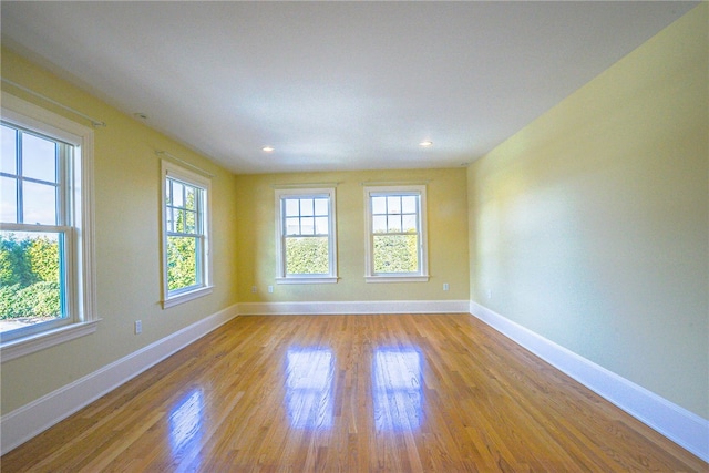 unfurnished room with baseboards, wood finished floors, and recessed lighting