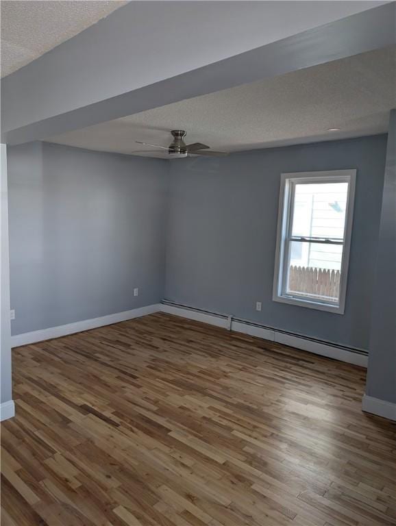 unfurnished room featuring wood finished floors, a ceiling fan, baseboards, a baseboard radiator, and a textured ceiling