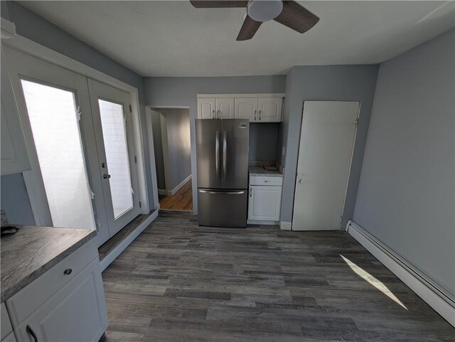 kitchen featuring white cabinets, dark wood-style flooring, freestanding refrigerator, french doors, and a baseboard heating unit