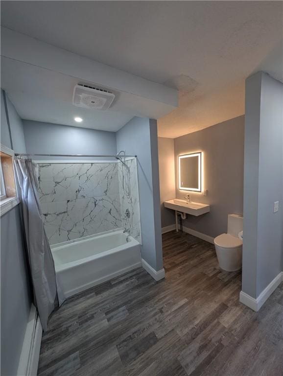 full bathroom featuring toilet, wood finished floors, and shower / tub combo with curtain