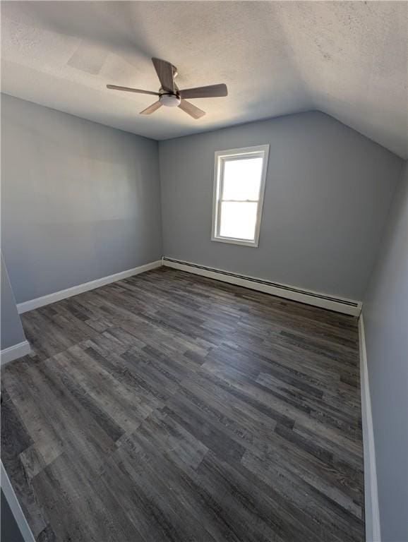 empty room with baseboards, lofted ceiling, dark wood-type flooring, a textured ceiling, and a baseboard heating unit