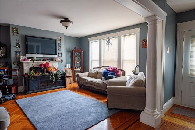 living room featuring a fireplace and decorative columns