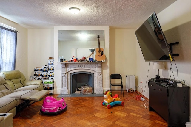 living room featuring radiator, a fireplace, and a textured ceiling