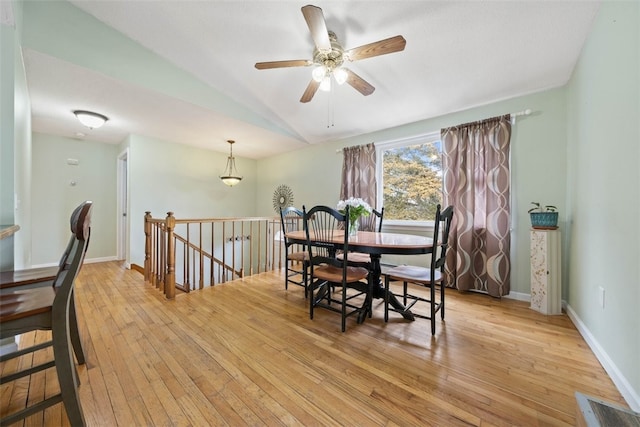 dining space with light wood finished floors, baseboards, vaulted ceiling, and a ceiling fan