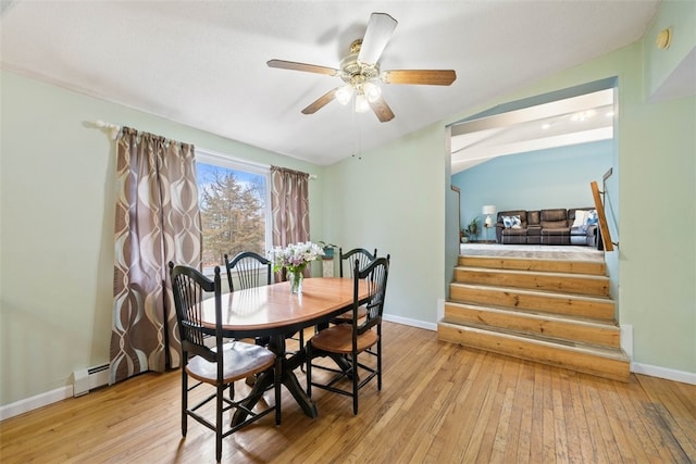 dining space with baseboards, hardwood / wood-style floors, and stairs