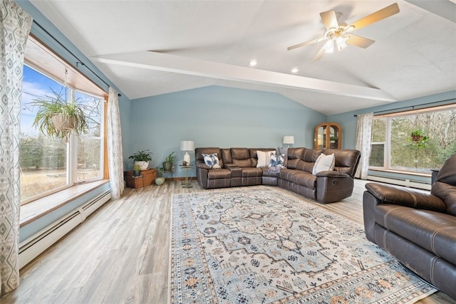 living area with a wealth of natural light, a baseboard heating unit, vaulted ceiling, and wood finished floors