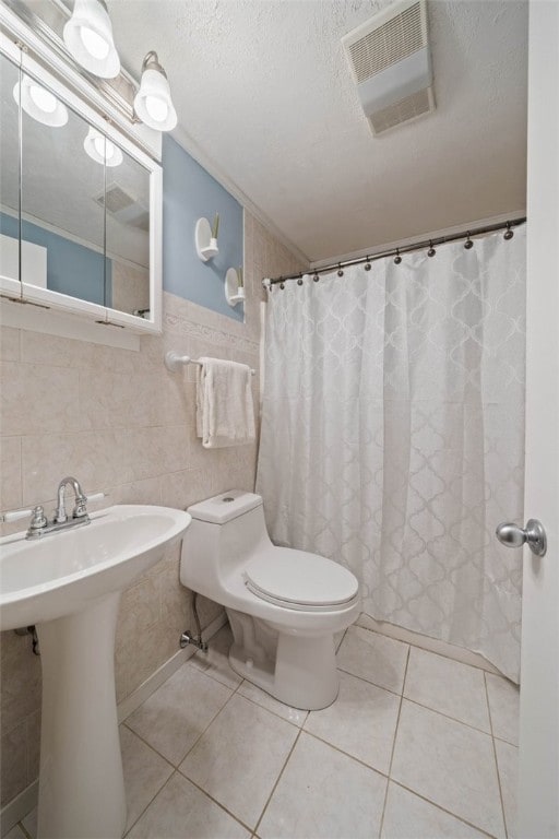 full bath featuring visible vents, toilet, ornamental molding, a textured ceiling, and tile patterned floors