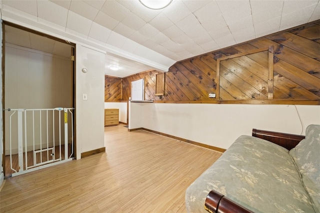 interior space with wood walls, baseboards, and wood finished floors