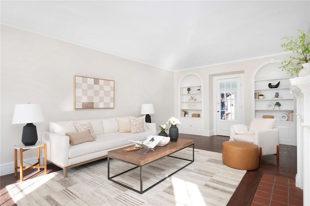 living room featuring built in shelves, wood finished floors, and baseboards