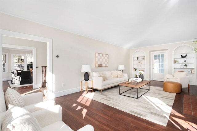 living area with built in shelves, baseboards, and wood finished floors