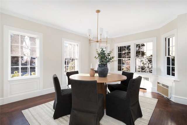 dining area with a chandelier, crown molding, baseboards, and wood finished floors