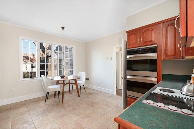 kitchen with light tile patterned floors, stainless steel double oven, baseboards, stovetop, and brown cabinetry