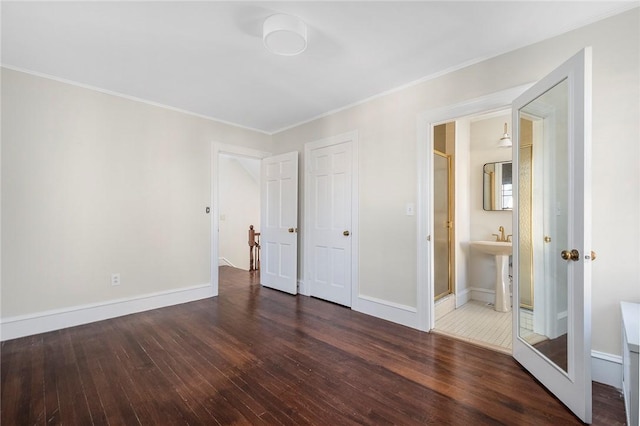 unfurnished bedroom with ornamental molding, baseboards, and wood finished floors