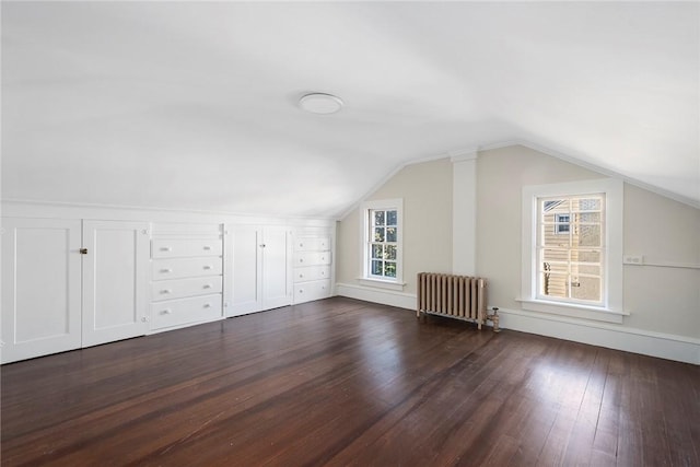 bonus room with radiator, a healthy amount of sunlight, vaulted ceiling, and dark wood-type flooring