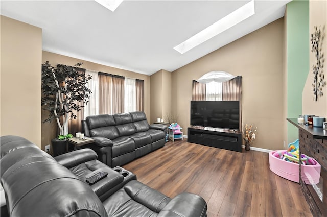 living area featuring lofted ceiling with skylight, baseboards, and wood finished floors