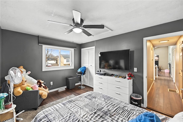 bedroom with visible vents, baseboards, a ceiling fan, wood finished floors, and a closet