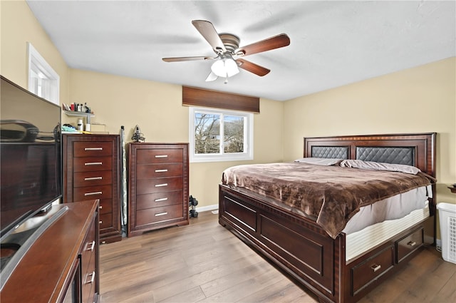 bedroom with a ceiling fan, baseboards, and wood finished floors