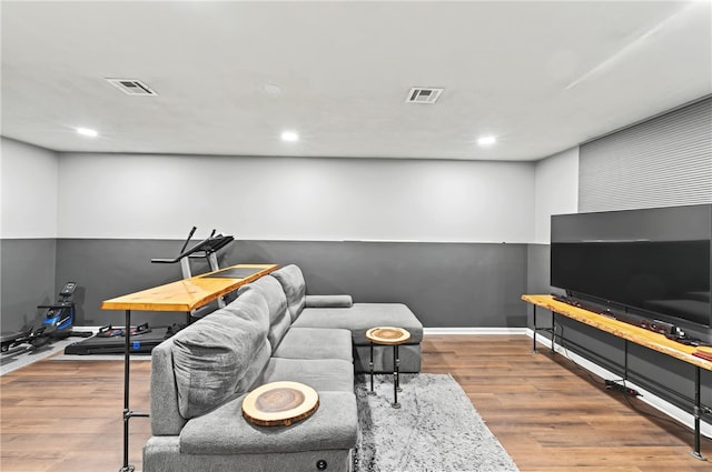 living area featuring recessed lighting, visible vents, and wood finished floors