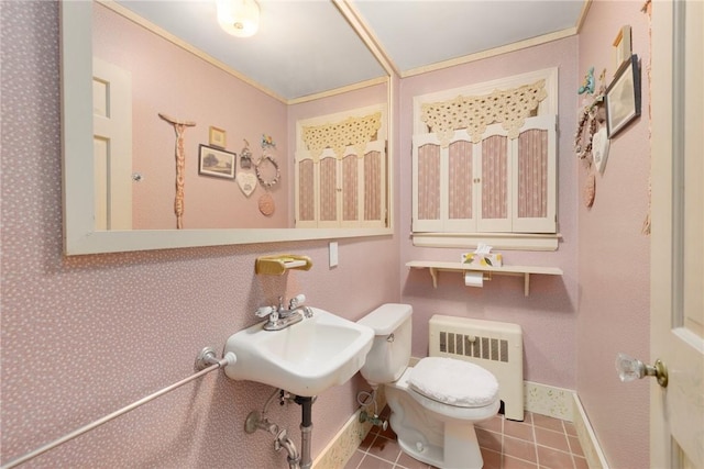 half bathroom with baseboards, tile patterned flooring, toilet, and radiator