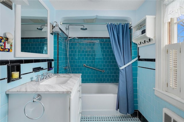 full bathroom featuring visible vents, vanity, tile walls, and shower / bathtub combination with curtain