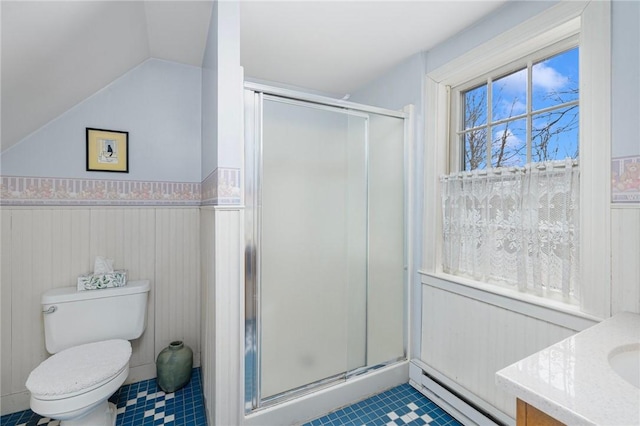 bathroom with a stall shower, wainscoting, toilet, vaulted ceiling, and baseboard heating