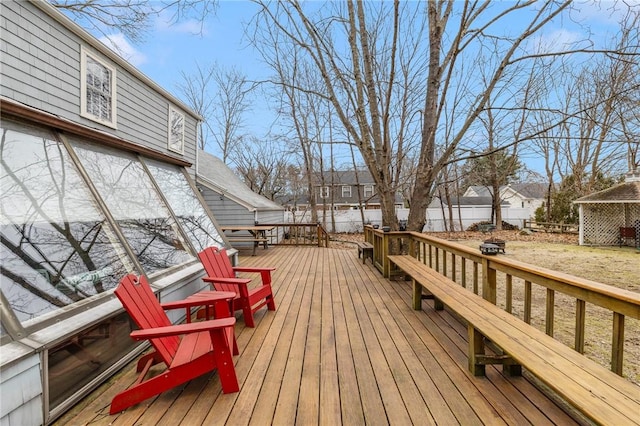 wooden terrace featuring an outdoor fire pit and a fenced backyard