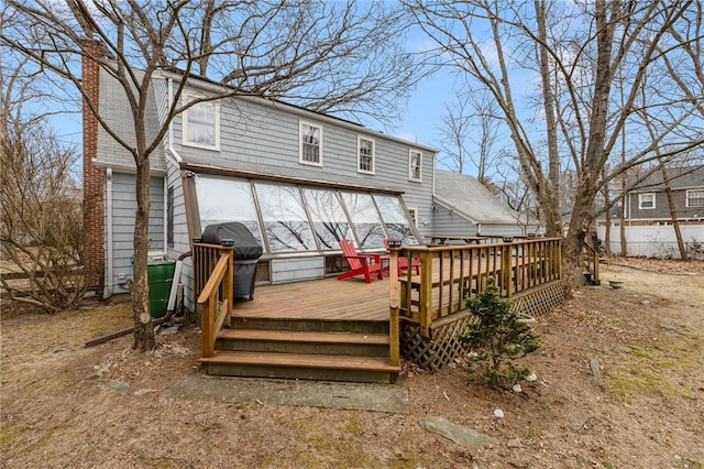 rear view of house with a deck and a chimney