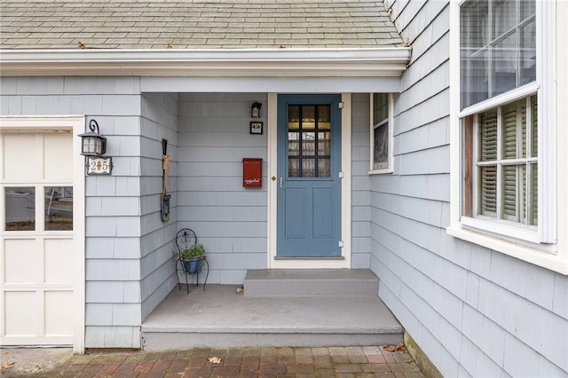 entrance to property with roof with shingles